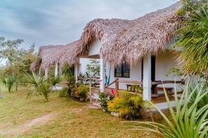 ein Häuschen mit Reetdach, Tisch und Stühlen in der Unterkunft Hotel - CABAÑAS THAJU - HUASTECA POTOSINA in El Naranjito