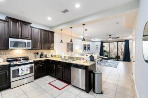 una cocina con armarios de madera oscura y una isla de cocina en *Roseville Disney Villa Pool+BBQ+King Bed+Parks*, en Kissimmee