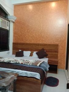 a bedroom with a large bed with a wooden headboard at Ramam hotel by Naavagat Ayodhya in Ayodhya