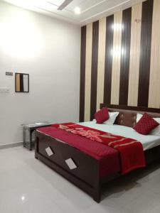 a bedroom with a large bed with a red blanket at Ramam hotel by Naavagat Ayodhya in Ayodhya