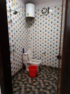 a bathroom with a toilet and a wall with polka dots at Entire 3 BHK flat for guest. in New Delhi