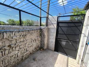 una puerta a un edificio con una pared de ladrillo en Alojamiento Donatello, en Durazno