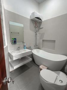 a white bathroom with a toilet and a sink at Vũ Homestay in Cao Bằng