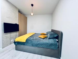 a bedroom with a bed with blue sheets and yellow pillows at Cozy apartments in Riga
