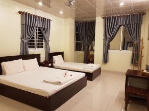 um quarto com 2 camas e um espelho em Hostel Đặng Lợi ホステルダンロイ em Chau Doc