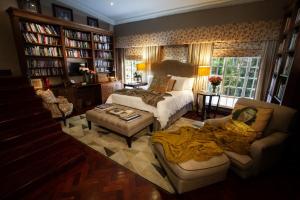 um quarto com uma cama e uma mulher deitada num sofá em The Great Gatsby Houghton em Joanesburgo