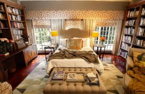 1 dormitorio con 1 cama grande y estanterías en The Great Gatsby Houghton en Johannesburgo