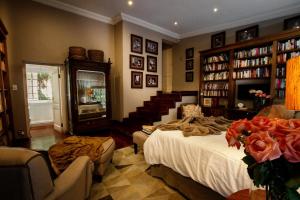 um quarto com uma cama e uma escada com livros em The Great Gatsby Houghton em Joanesburgo