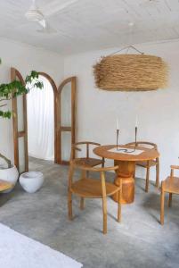 Habitación con mesa, sillas y techo. en Villa AMMA 2 quartos c/Jacuzzi, en Ahangama