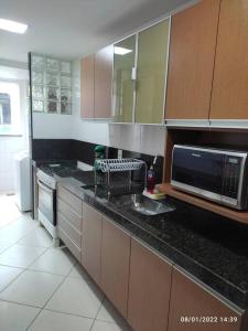 uma cozinha com um lavatório e um micro-ondas em Apartamento encantador a 250 m da Praia do Forte em Cabo Frio