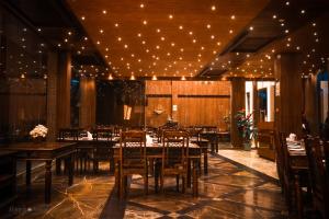 a dining room with tables and chairs and lights at Haywizz Havelock Island Resort in Havelock Island