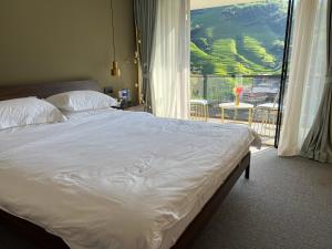 a bedroom with a large bed and a large window at Lost In Beauty Guest House 龙脊梯田野望民宿 in Longsheng