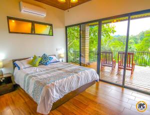 1 dormitorio con 1 cama y balcón en Modern Mountain View Home by Nauyaca Waterfall, en Platanillo