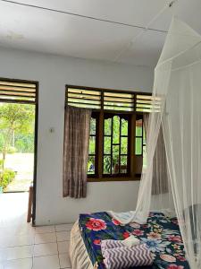 a bedroom with a bed with a mosquito net at Wisma Batu Mandi and offers jungle tours in Bukit Lawang