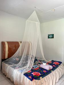Una cama con mosquitera encima. en Wisma Batu Mandi and offers jungle tours en Bukit Lawang