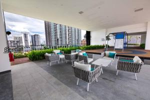 un patio con sillas y mesas y vistas a la ciudad en Urban Suites with Spectacular High Floor View #3BR #03, en Jelutong