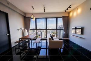 un soggiorno con tavolo e una grande finestra di Urban Suites with Spectacular High Floor View #3BR #03 a Jelutong