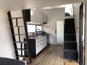 a small kitchen with a sink and a staircase in a tiny house at Tiny Zoe in Mount George +7 photos