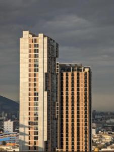 a view of two tall buildings in a city at BarrioW Apartment 1 Room, parking, pool and view in Monterrey