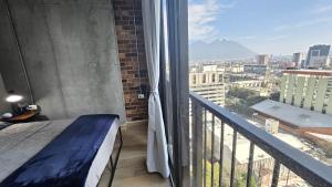 a bedroom with a balcony with a view of a city at Depto en el centro de Monterrey. in Monterrey