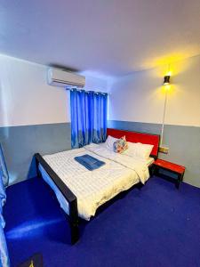 1 dormitorio con 1 cama con alfombra roja y azul en CORAL en Koh Rong Sanloem