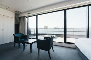 佐賀市にあるTAPSTAY HOTEL - Vacation STAY 35227vのベッド、テーブル、椅子が備わるホテルルームです。