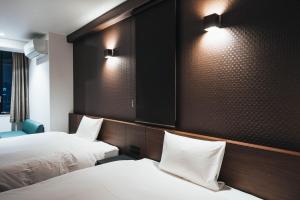 佐賀市にあるTAPSTAY HOTEL - Vacation STAY 35239vのベッド2台、壁に照明が備わるホテルルームです。