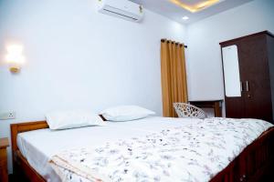 une chambre avec un lit et une chaise dedans dans l'établissement Isha Marari Beach homestay, à Mararikulam