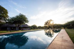 a swimming pool with the sun reflecting in the water at Lapeng Guest Lodge in Burgersfort
