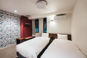 two beds in a room with red walls at TAPSTAY HOTEL - Vacation STAY 35235v in Saga