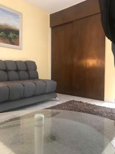 een woonkamer met een bank en een glazen tafel bij Habitacion #1 in Chihuahua