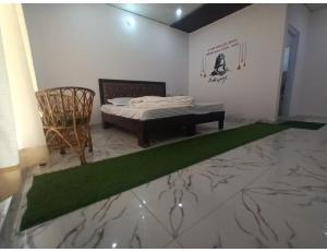 a bedroom with a bed and a green rug at Hotel PJ Dupeex, Ravigram, Phata in Phata