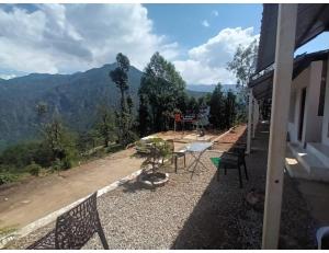 a balcony of a house with a view of a mountain at Hotel PJ Dupeex, Ravigram, Phata in Phata