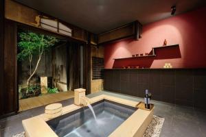 a bathroom with a bath tub with a fountain at Kyoto Machiya Zeniyacho in Kyoto