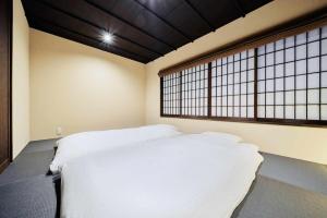 Rúm í herbergi á Kyoto Machiya Zeniyacho