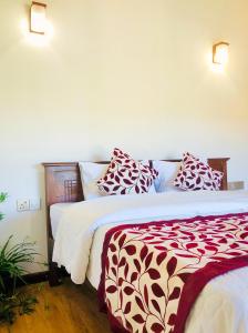 a bedroom with two beds with red and white pillows at Star Holiday Home in Nuwara Eliya