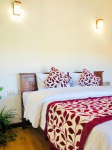1 dormitorio con 2 camas y almohadas rojas y blancas en Star Holiday Home, en Nuwara Eliya