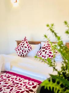uma cama com almofadas vermelhas e brancas em Star Holiday Home em Nuwara Eliya