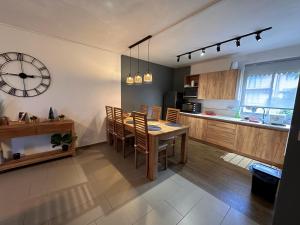 a kitchen and dining room with a table and a clock at Trou aux Biches Apartment in Trou aux Biches