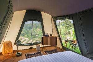 um quarto com uma cama numa tenda com janelas grandes em CAMP CAYLA - STELLAR em Chiang Mai