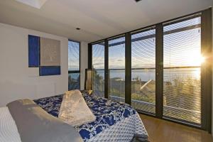 a bedroom with a bed and a large window at Coastal Escape in Nelson