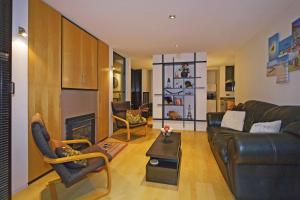 uma sala de estar com um sofá de couro e uma lareira em Coastal Escape em Nelson