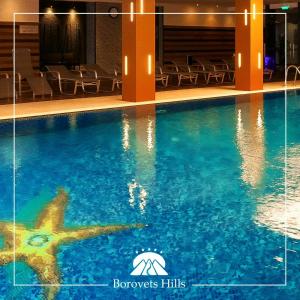a swimming pool with a star in the water at BH and Semiramida Ski Apartment in Borovets