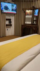 a bedroom with a bed and a flat screen tv at Bandara Villa Nuwaraeliya in Nuwara Eliya +15 photos