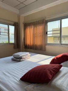 a bedroom with a large bed with two pillows on it at KC guest house in Bangkok