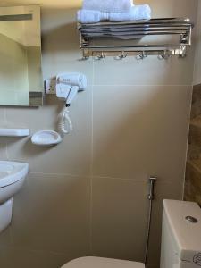 a bathroom with a toilet and towels on a wall at Bandara Villa Nuwaraeliya in Nuwara Eliya