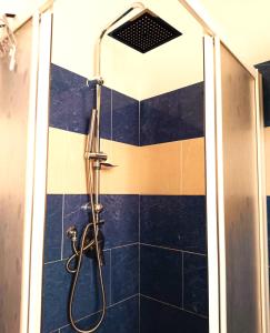 um chuveiro numa casa de banho com azulejos azuis em vista mare em Portovenere