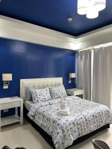 um quarto azul com uma cama e duas mesas em Condo Palm Tree 1 Across NAIA T3 em Manila
