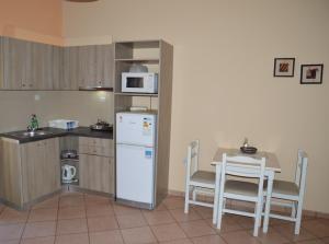 a kitchen with a white refrigerator and a table with chairs at Melia Studios in Kato Daratso