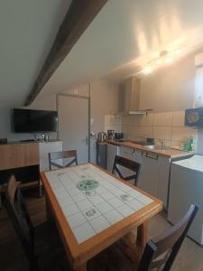 uma cozinha com uma mesa e algumas cadeiras e uma mesa e uma cozinha em Le gîte du Vivier - Loches em Loches